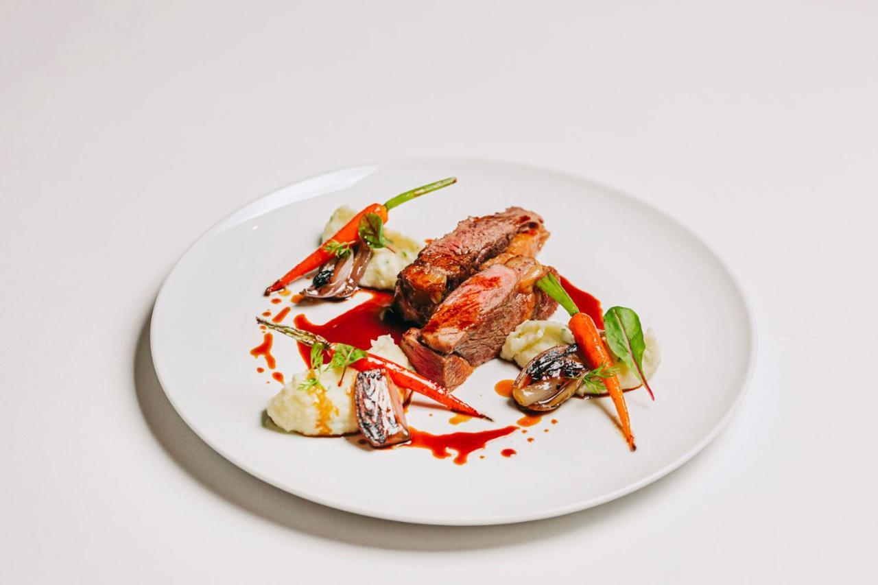 Ap Lago Montargil - Conference & Spa Экстерьер фото The photo features a beautifully plated dish. At the center, there are slices of a tender meat, likely beef, showcasing a juicy pink interior. Accompanying the meat are several elements: vibrant orange carrots, perhaps roasted or glazed, and dollops 