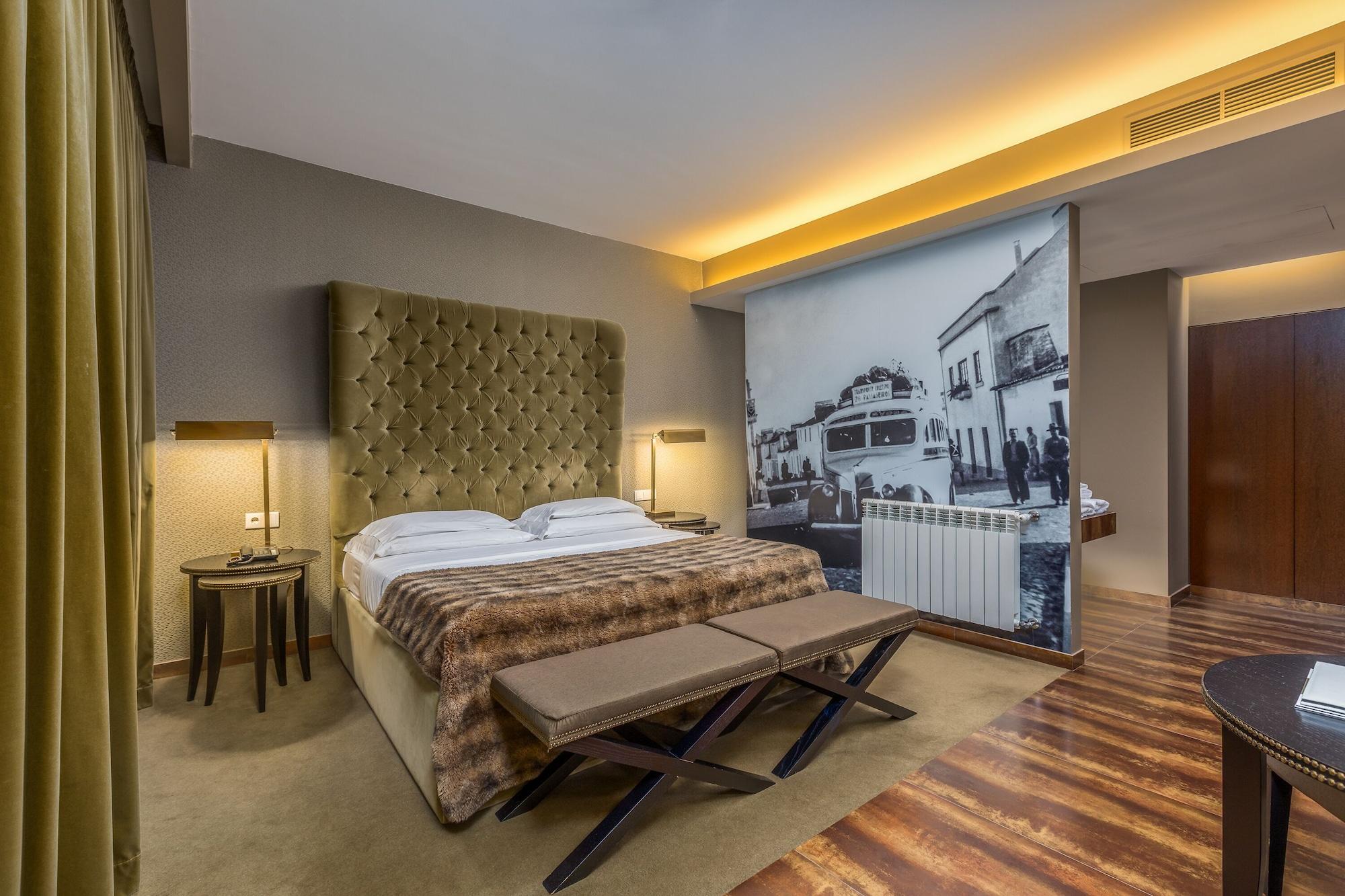 Ap Lago Montargil - Conference & Spa Экстерьер фото The photo shows a modern hotel room featuring a king-sized bed with a tufted headboard, dressed in white linens and a decorative throw blanket. On either side of the bed, there are bedside tables with lamps. The room is well-lit, with an ambient ceil